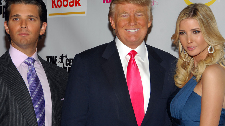 Don Jr., Donald Trump and Ivanka Trump pose at an event