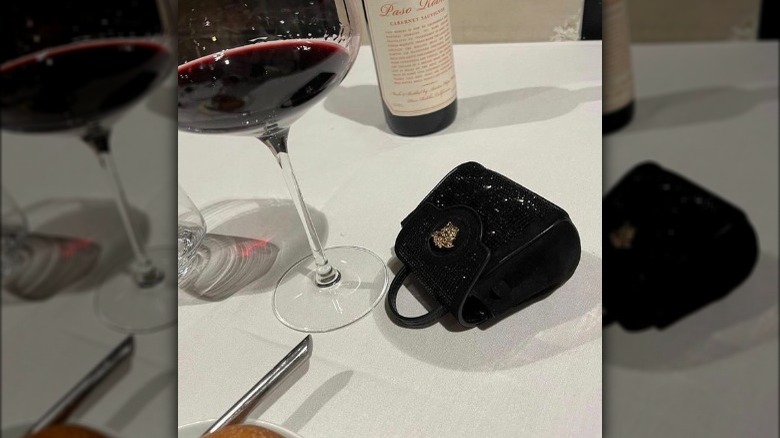 Versace Medusa mini bag next to wine glass