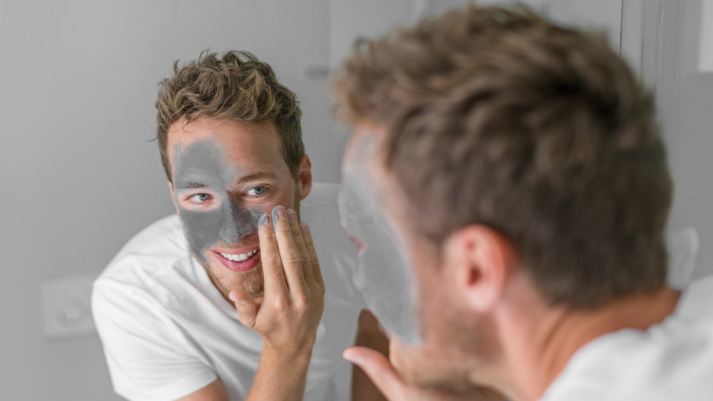 Man putting on a mud mask