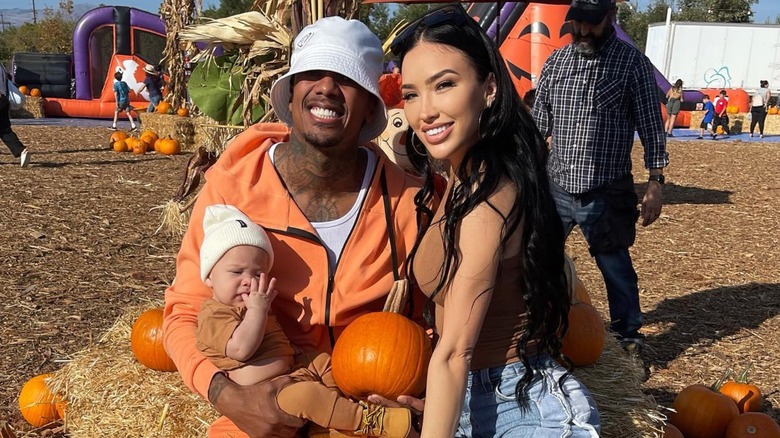 Bre Tiesi and Nick Cannon posing with son, Legendary