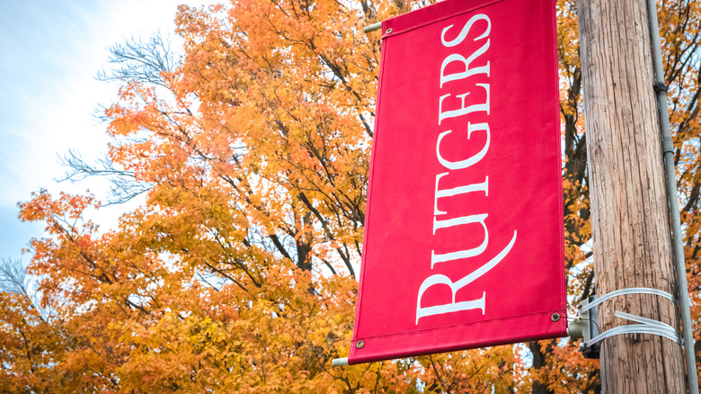 A red Rutgers flag hanging from a pole