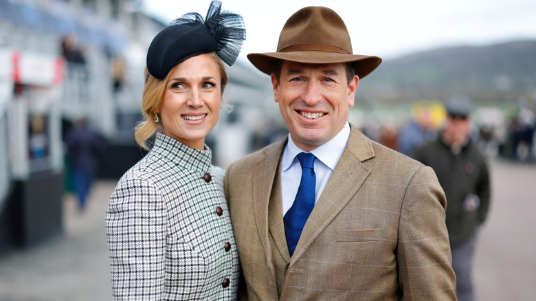 Peter Phillips and Harriet Sperling smiling together for a photo (although Sperling is looking off camera) against a blurred background