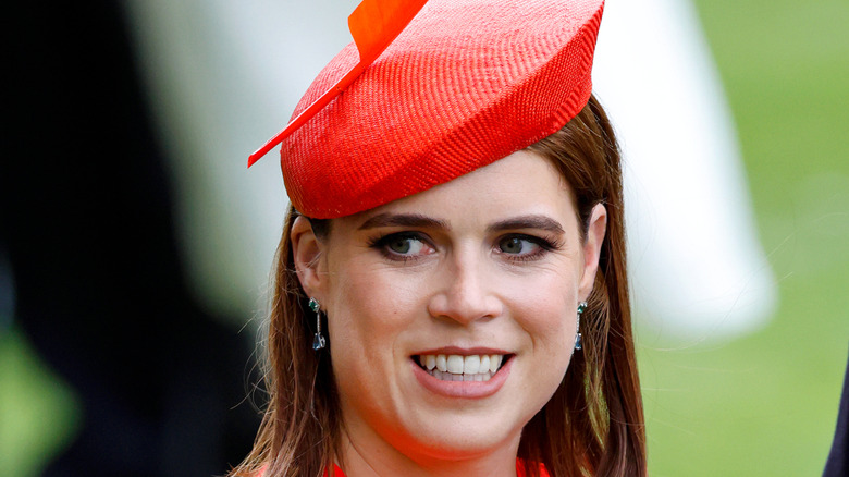 Princess Eugenie smiling in a red fascinator at 2025 Royal Ascot