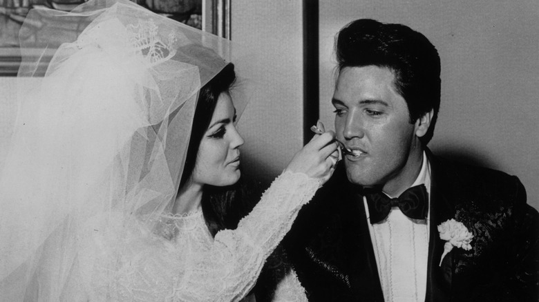 Elvis and Priscilla Presley eating cake at their wedding