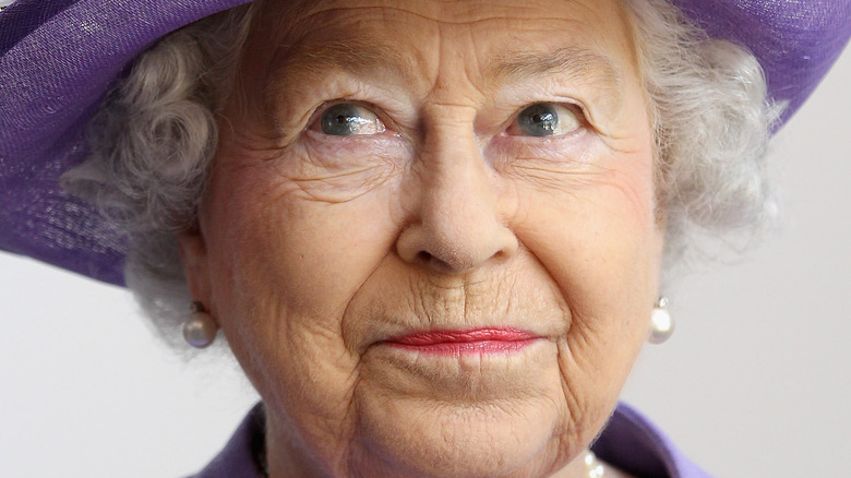 Queen Elizabeth smiling wearing all purple