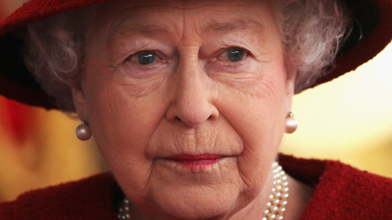 Queen Elizabeth looking stoic in red