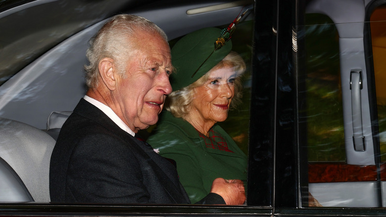 King Charles III and Queen Camilla in the backseat of a car