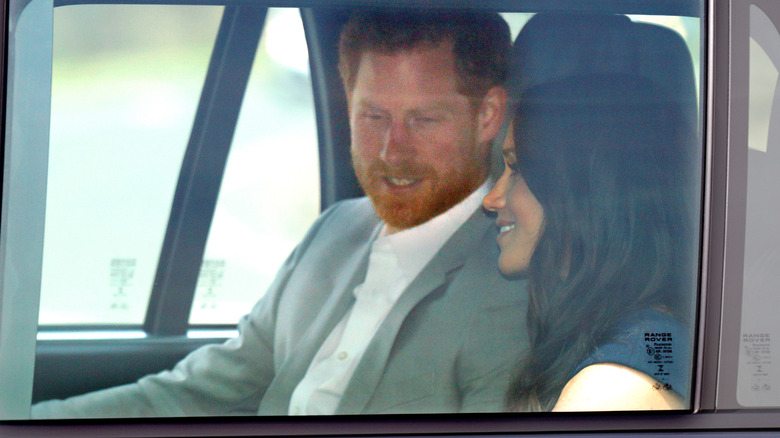 Prince Harry and Meghan Markle in the backseat of a car