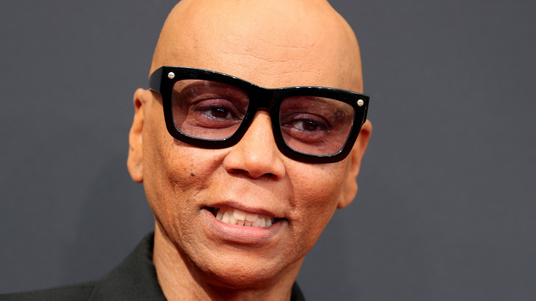  RuPaul's in thick glasses smiling