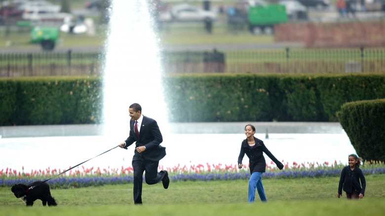 Barack, Sasha and Malia Obama walking Bo