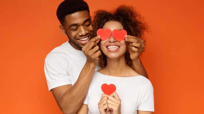 couple holding paper hearts