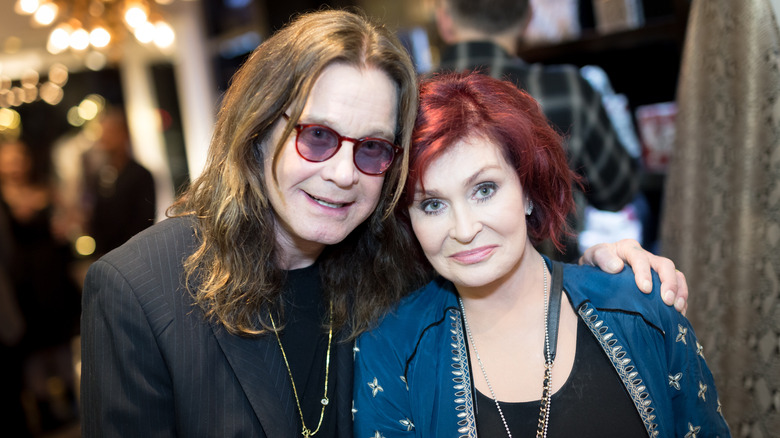Ozzy and Sharon Osbourne embracing as they pose for a photo