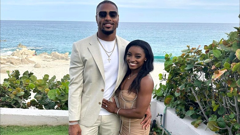 Jonathan Owens and wife Simone Biles stand in front of water