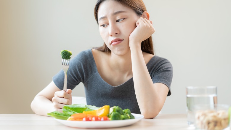 woman looking at food on a fork