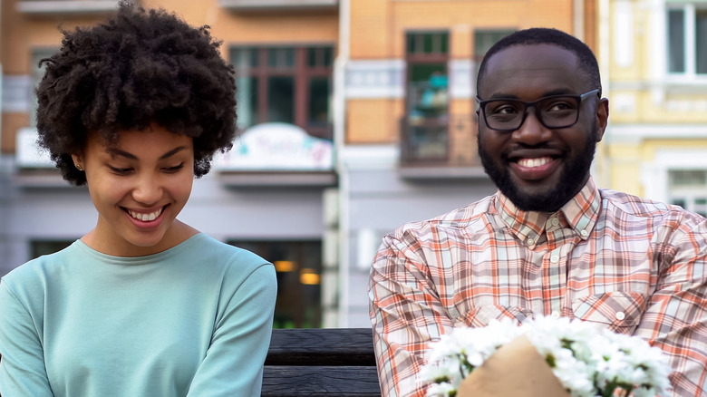 awkward couple smiling on bench