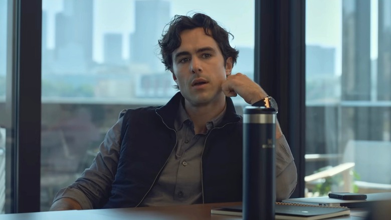 Ben Schnetzer in shirt and vest sitting at table in front of window in "Swiped"