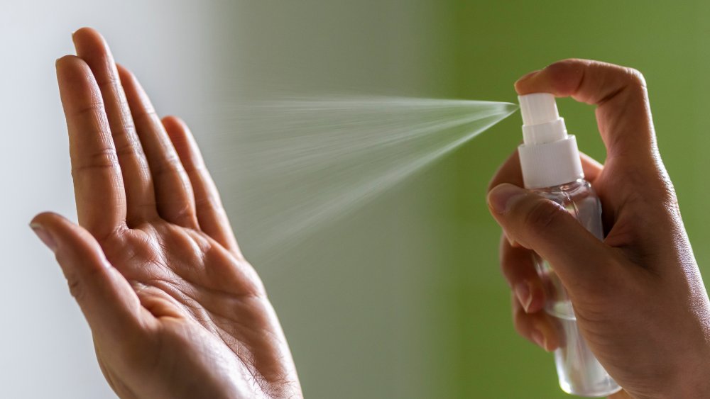 Spraying on hand sanitizer