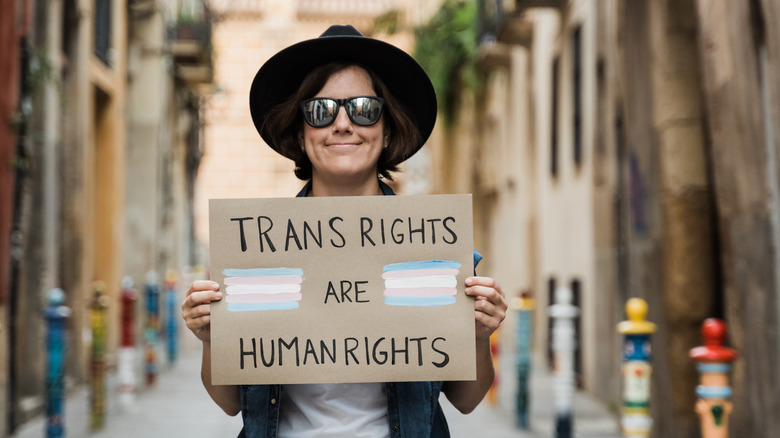A protestor holding up a trans rights sign