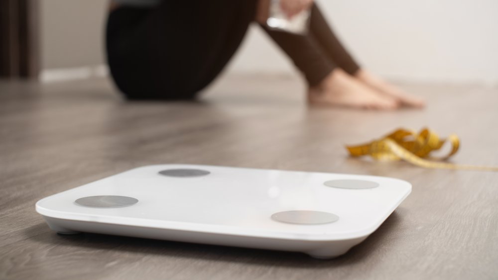 Woman sitting next to a scale