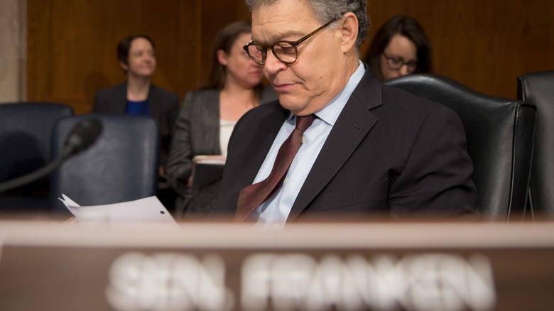 Senator Al Franken sitting behind a desk in a congressional hearing
