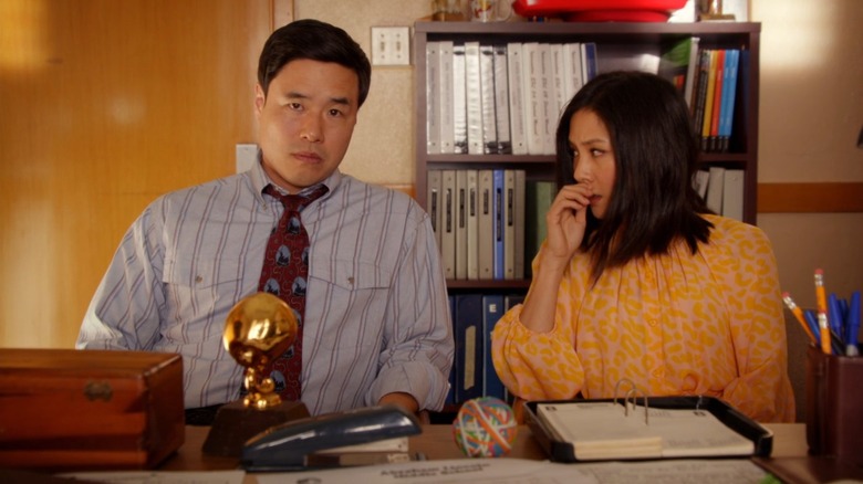 Randall Park and Constance Wu as Louis and Jessica Huang on Fresh Off The Boat, sitting concerned in front of a teacher's desk