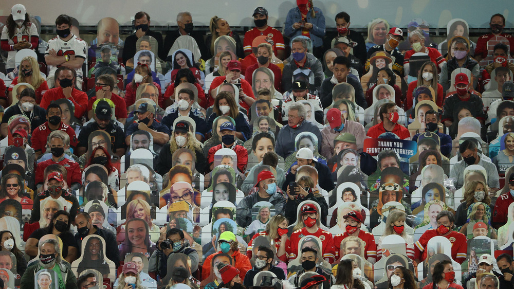 Fans mingle with cardboard cutouts at the stadium