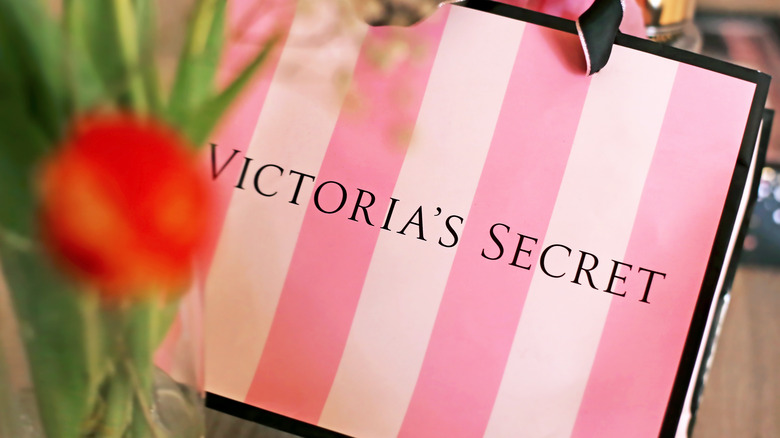 Victoria's Secret bag behind a flower vase