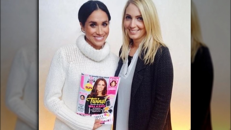 Meghan Markle posing with magazine cover featuring Kate Middleton