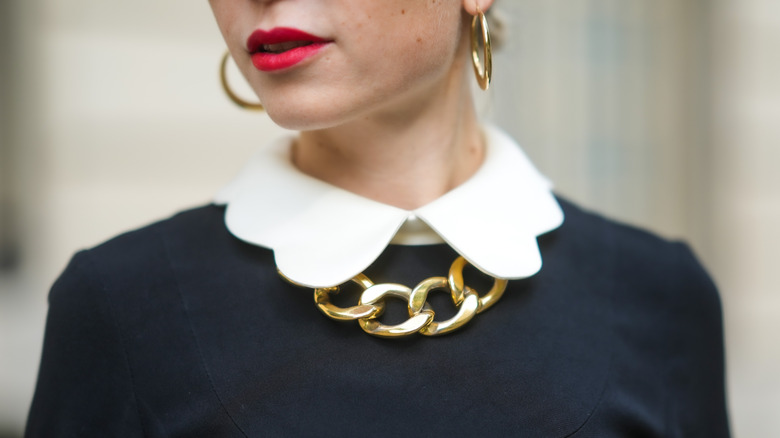 Woman wearing a Peter Pan collar and chunk jewelry street style