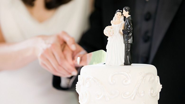 bride, groom cutting wedding cake 
