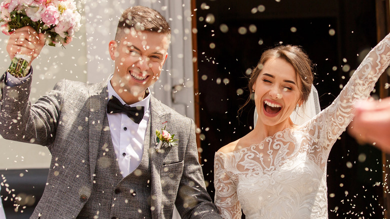 bride, groom celebrating with confetti