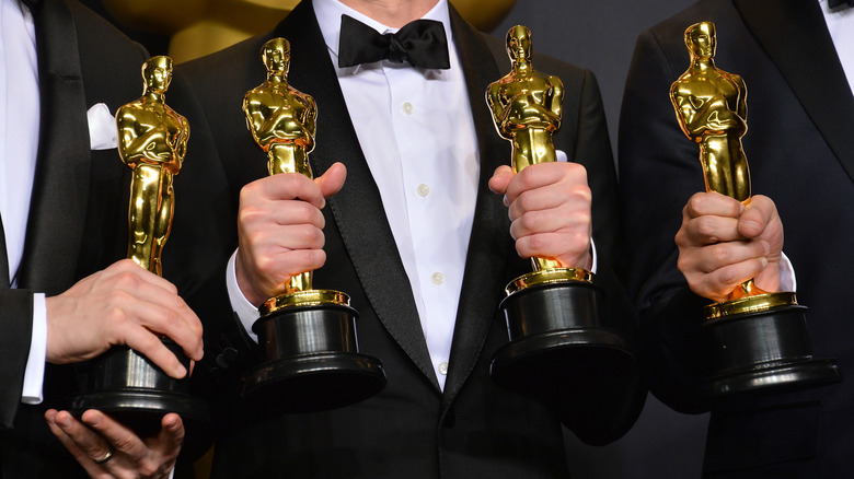 Oscar winners holding statues 