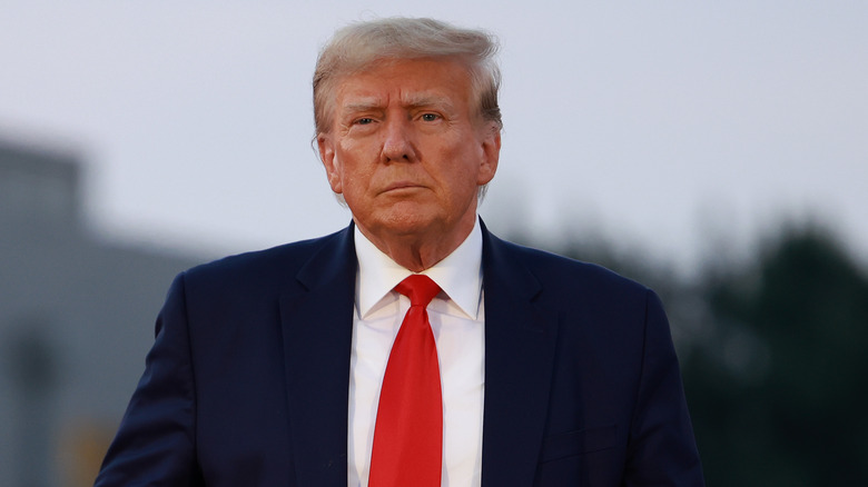 Donald Trump red tie looking serious at Georgia indictment