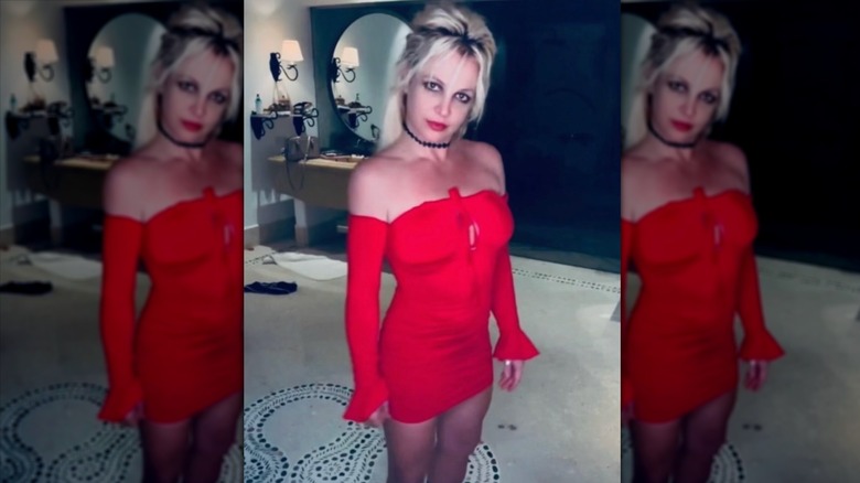 Britney Spears in red strapless dress with long sleeves and hair up