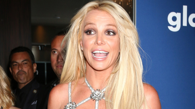Britney Spears in silver dress with hair down and mouth open