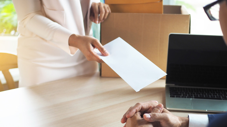 Woman in a white suit handing in resignation