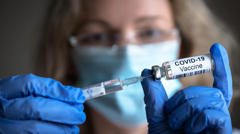 Women holding COVID-19 vaccine 