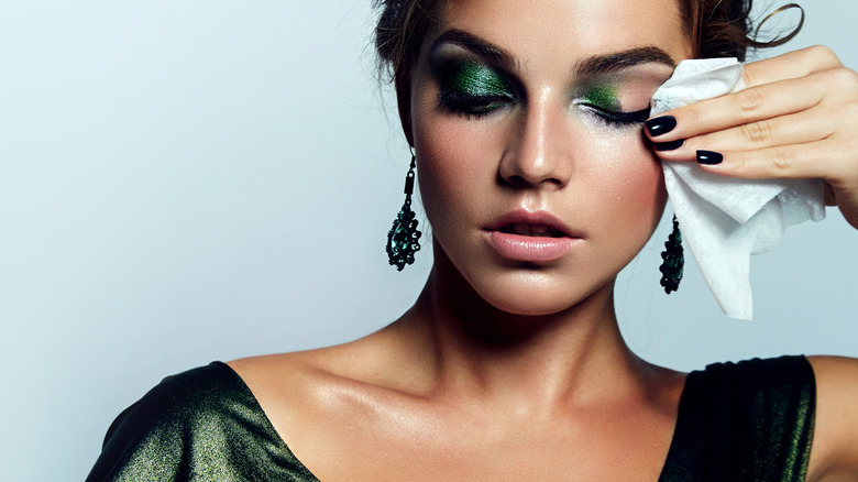 Woman wiping off eye makeup