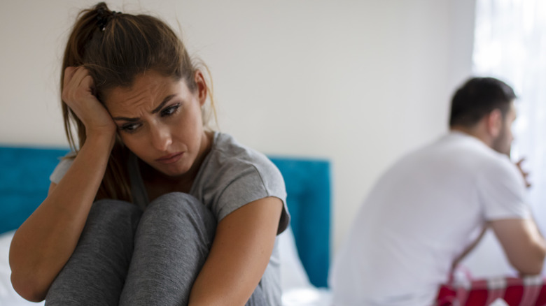 sad couple separated in bed