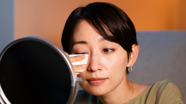 woman taking eye makeup off
