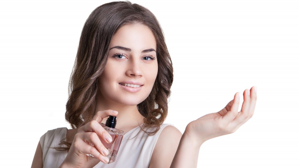 Woman applying perfume