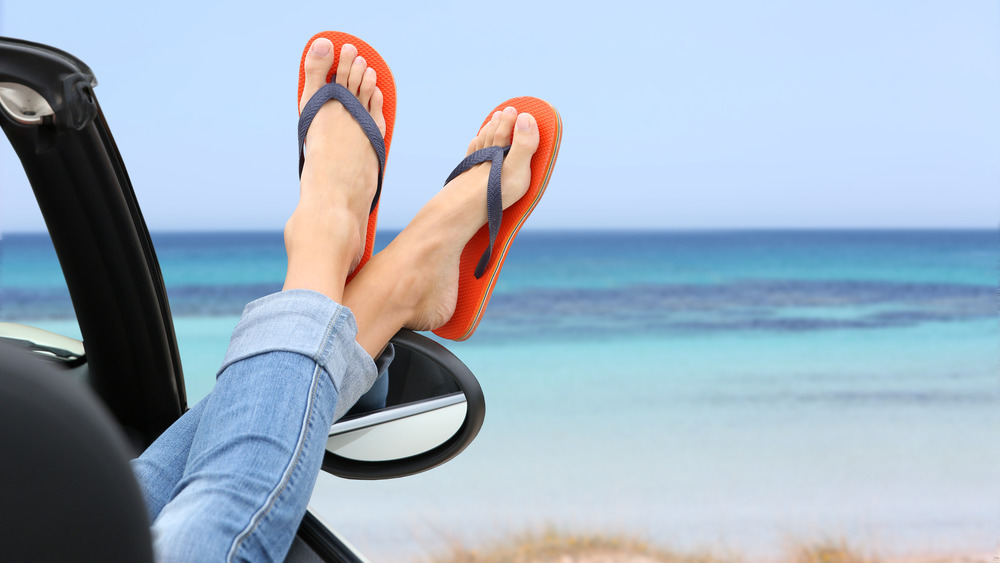 Person with flip-flops sticking feet out car window