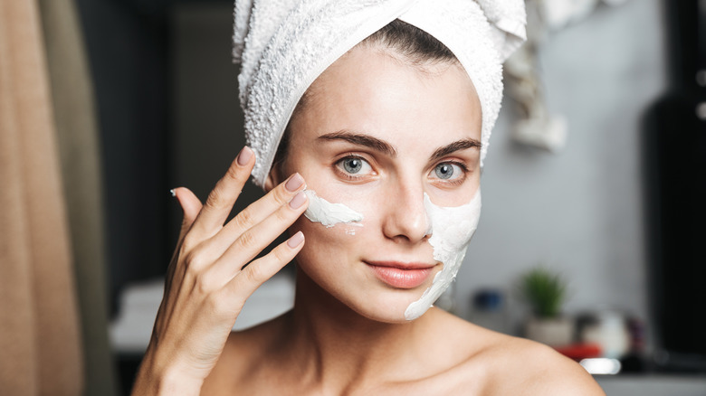 Woman putting on face mask