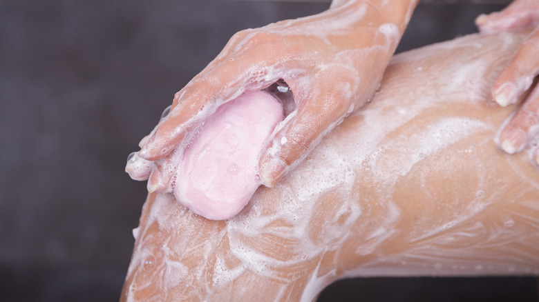 Woman soaping her leg