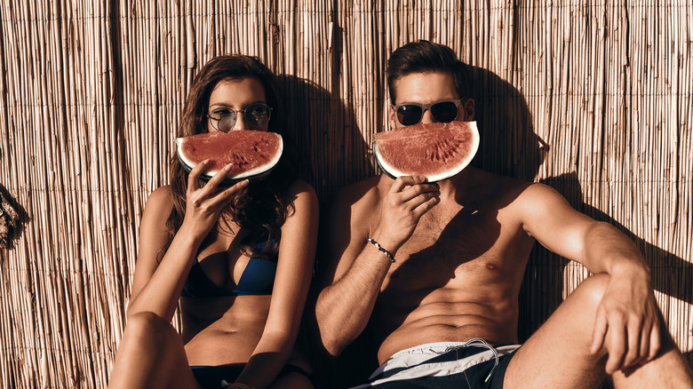 Couple sitting outside with watermelon