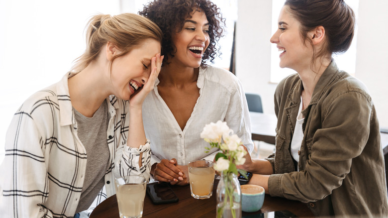 friends laughing at a cafe 