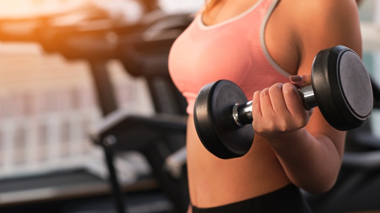 woman doing bicep curl with dumbbell