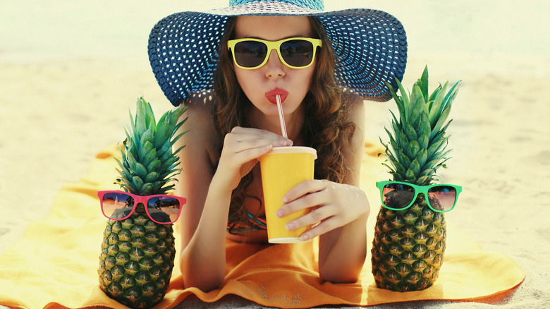 Young woman drinking fresh pineapple juice