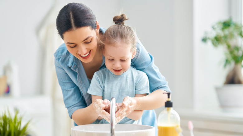 Mother and daughter washing hands