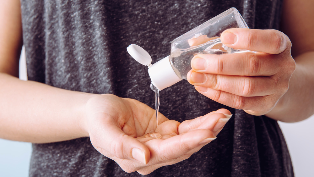 A woman's hands holding hand sanitizer